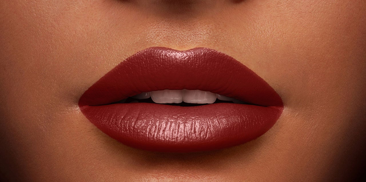 Maroon burgundy lipstick worn on model with a medium skin tone